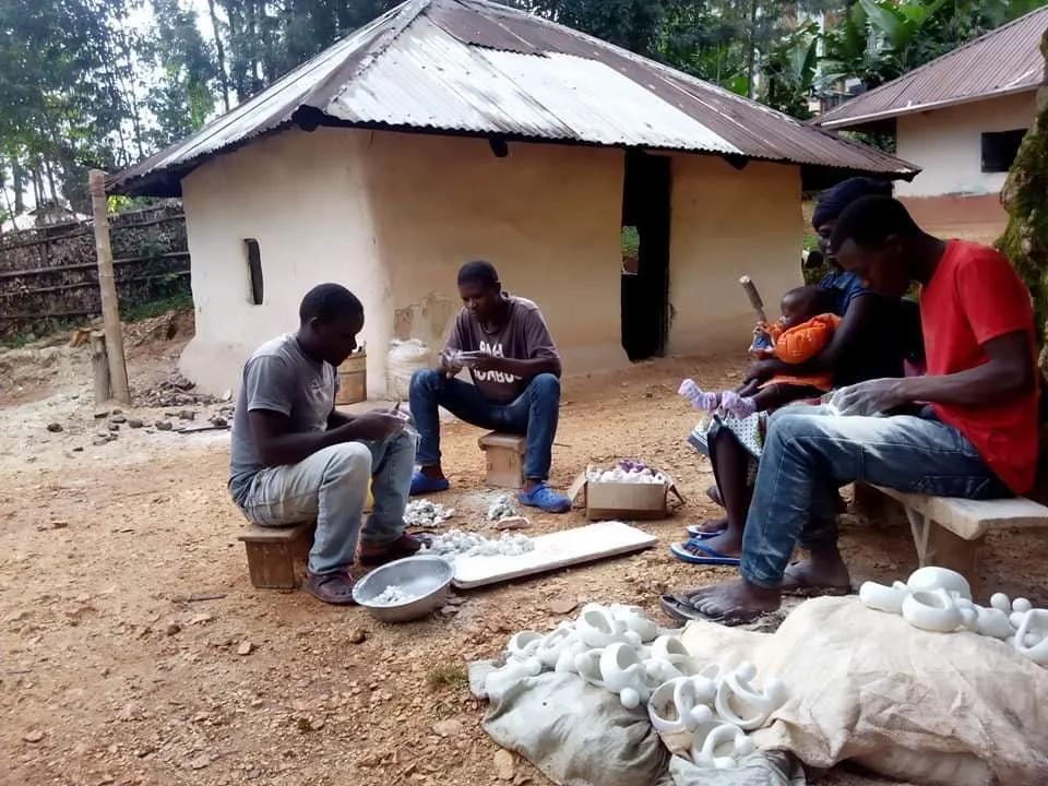 Carvers shaping white soapstone outside a workshop in Kisii, Kenya