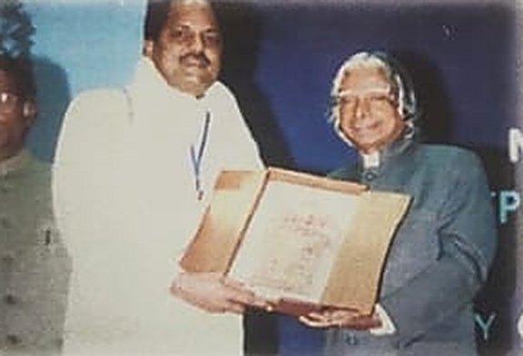 A member of the Marotia family receiving a framed certificate