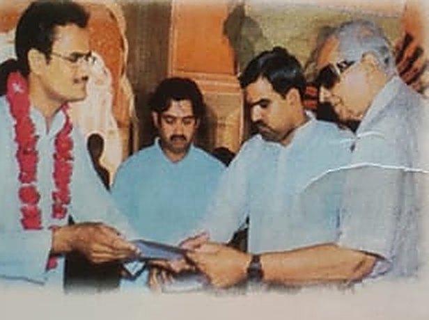 A garlanded member of the family receiving a certificate